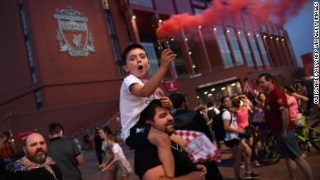 Fans celebrate Liverpool winning the championship title of the English Premier League following Chelsea&#39;s 2-1 victory over Manchester City, outside  Anfield stadium in Liverpool, north west England on june 25, 2020. - Liverpool were crowned Premier League champions without kicking a ball on Thursday as Chelsea&#39;s 2-1 win over Manchester City ended the Reds&#39; 30-year wait to win the English title. (Photo by Oli SCARFF / AFP) (Photo by OLI SCARFF/AFP via Getty Images)